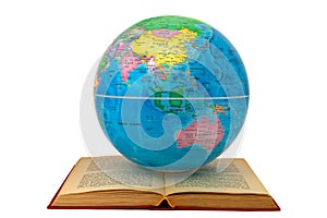 Earth globe on an open book showing Asia and Australia: study and learning concept. The open book symbolizes reading, study and