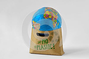 Earth globe in a paper shopping bag with the written Say no to p