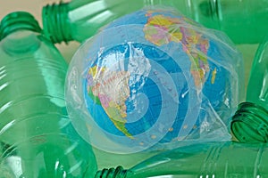 Earth globe in plastic bag among plastic bottles - Concept of ecology and stop plastic pollution