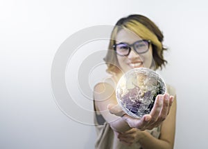 Earth in hand. World, small globe hold and showing by happy Asian woman`s hand.