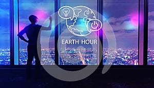 Earth hour with man by large windows at night