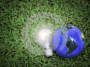 Earth with light bulb on green grass, energy-saving, save the world, love and  protect our planet, environmental  friendly concept