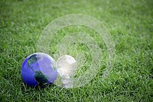 Earth with light bulb on green grass, energy-saving, save the world, love and protect our planet, environmental  friendly concept