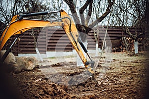 Earth loader, industrial heavy duty excavator moving soil during landscaping works