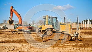 earth mover bulldozer and excavator at construction site