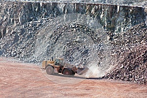 Earth mover driving around in a surface mine quarry