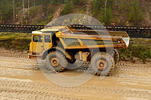 Earth mover loading dumper truck with sand in quarry. Excavator loading sand into dumper truck.Quarry for the extraction of minera photo