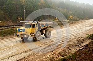 Earth mover loading dumper truck with sand in quarry. Excavator loading sand into dumper truck.Quarry for the extraction of minera photo