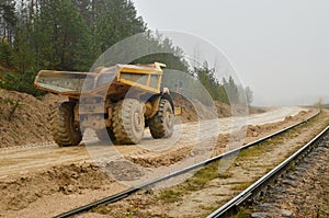 Earth mover loading dumper truck with sand in quarry. Excavator loading sand into dumper truck.Quarry for the extraction of minera photo