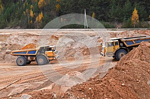 Earth mover loading dumper truck with sand in quarry. Excavator loading sand into dumper truck.Quarry for the extraction of