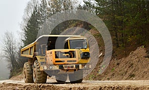 Earth mover loading dumper truck with sand in quarry. Excavator loading sand into dumper truck.Quarry for the extraction of minera photo