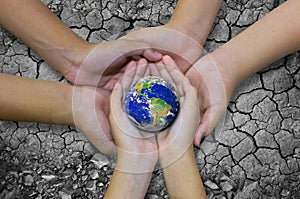 Earth planet in asian Children hand isolated on Ground arid barr