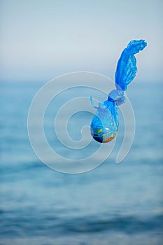 The Earth in a plastic bag. World Environment Day concept.