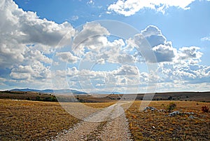 Earth road, blue sky and clouds