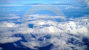 The earth and sky aerial view from the airplane. Blue sky and cloud vibrant color. Blue summer sky with white clouds background.