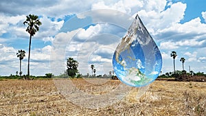 Earth in water drop shape floating on barren rice fields