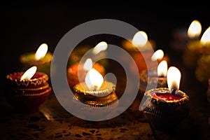 Earthen diya lamp lighting with candles on the occasion of diwali and sandhi pujo