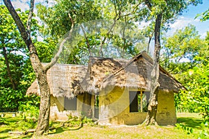 Earthen house under shade of trees. An earth house, also known as earth berm, earth sheltered home, or eco-house is an architectur