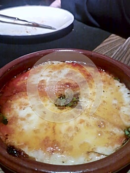 Earthenware dish with baked provolone cheese