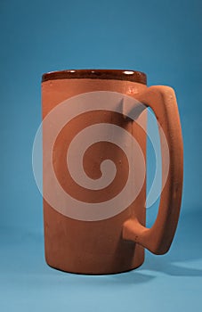 Earthenware jug with blue background (vertical) with interesting light. Concept of wellness, freshness, warm, etc.