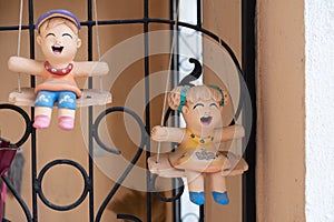 Earthernware child doll on the swing