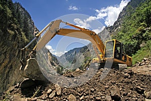 Earthmover bulldozer in himalayas clearing landslide photo
