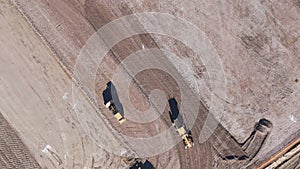 Earthmoving equipment. Aerial view of a large construction site with several earthmoving machines.