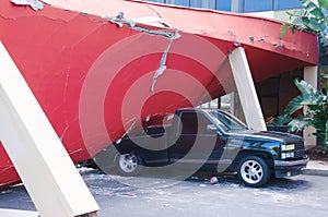 Earthquake damaged building crushed truck vehicle