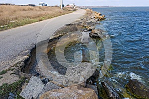 After an earthquake and strong storm in winter and severe destructive frost, asphalt road on landslide swept into sea. Closed road