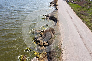 After an earthquake and strong storm in winter and severe destructive frost, asphalt road on landslide swept into sea. Closed road