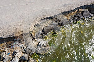 After an earthquake and strong storm in winter and severe destructive frost, asphalt road on landslide swept into sea. Closed road