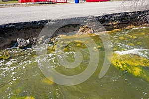 After an earthquake and strong storm in winter and severe destructive frost, asphalt road on landslide swept into sea. Closed road