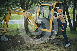 Earthwork concept. Earthwork operator at excavator. Man climb on digger for earthwork. Earthwork and ground work