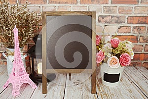 Easel blackboard empty mock up space for copy with flower decoration on wooden background