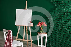 Easel with canvas and chair in artist\'s workshop