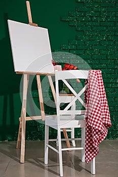 Easel with canvas and chair in artist's workshop