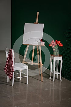 Easel with canvas and chair in artist's workshop