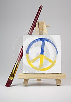 Easel with peace symbol and message stop the war