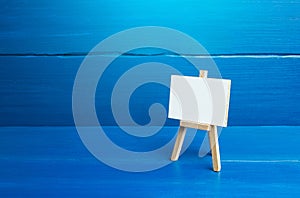 An easel with a white board on a blue background. Presentations, brainstorming, teaching, or artistic expression. Strategy