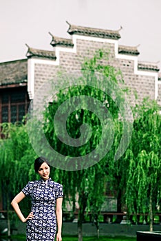 East cheongsam woman standing in Ma Tau wall