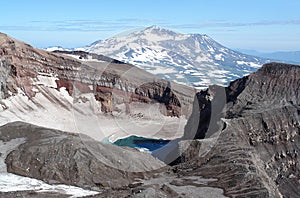The east crater of Gorely volcano with blue acid lake covered partially with ice in august