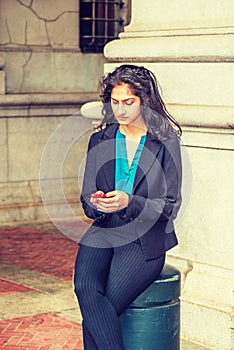 East Indian American college student texting outside in New York