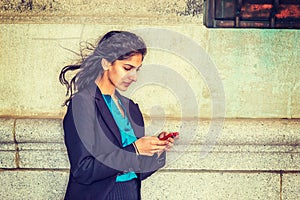 East Indian American college student texting outside in New York