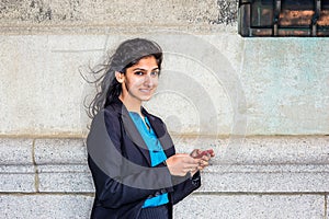 East Indian American college student texting outside in New York