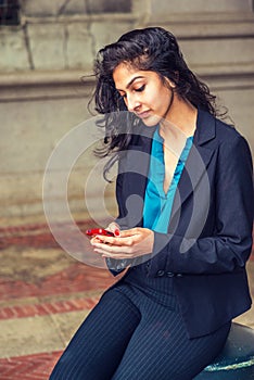 East Indian American college student texting outside in New York