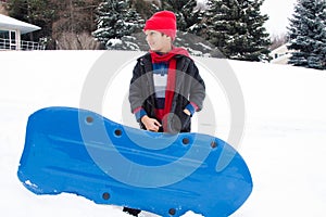 East Indian boy toboganning in the snow