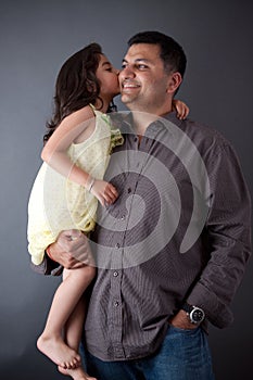 An East Indian girl kisses her father