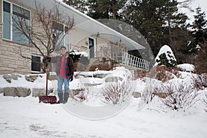 East Indian man shovelling snow