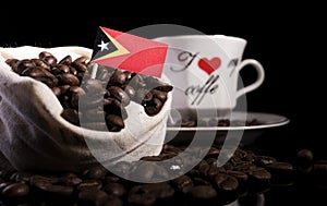 East Timorese flag in a bag with coffee beans on black