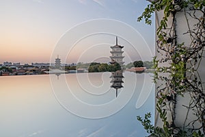 East and west towers of Kaiyuan Temple at dusk, with mirror reflection in foreground in Quanzhou